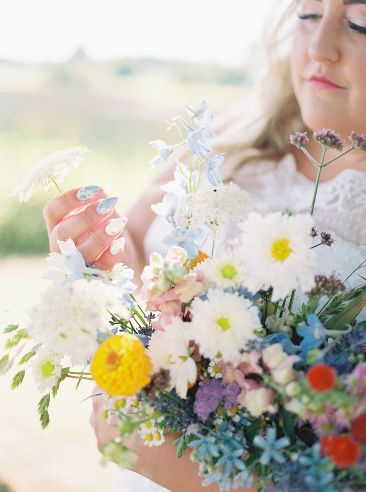 Bride Admiring Her Lush Bouquet of Colorful Wildflowers