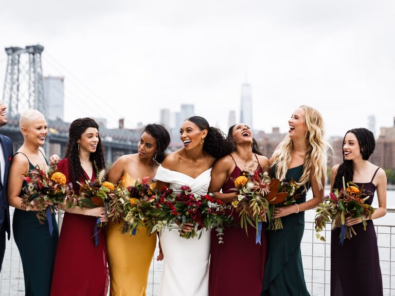 Bridesmaids wear various gowns in jewel tones. 