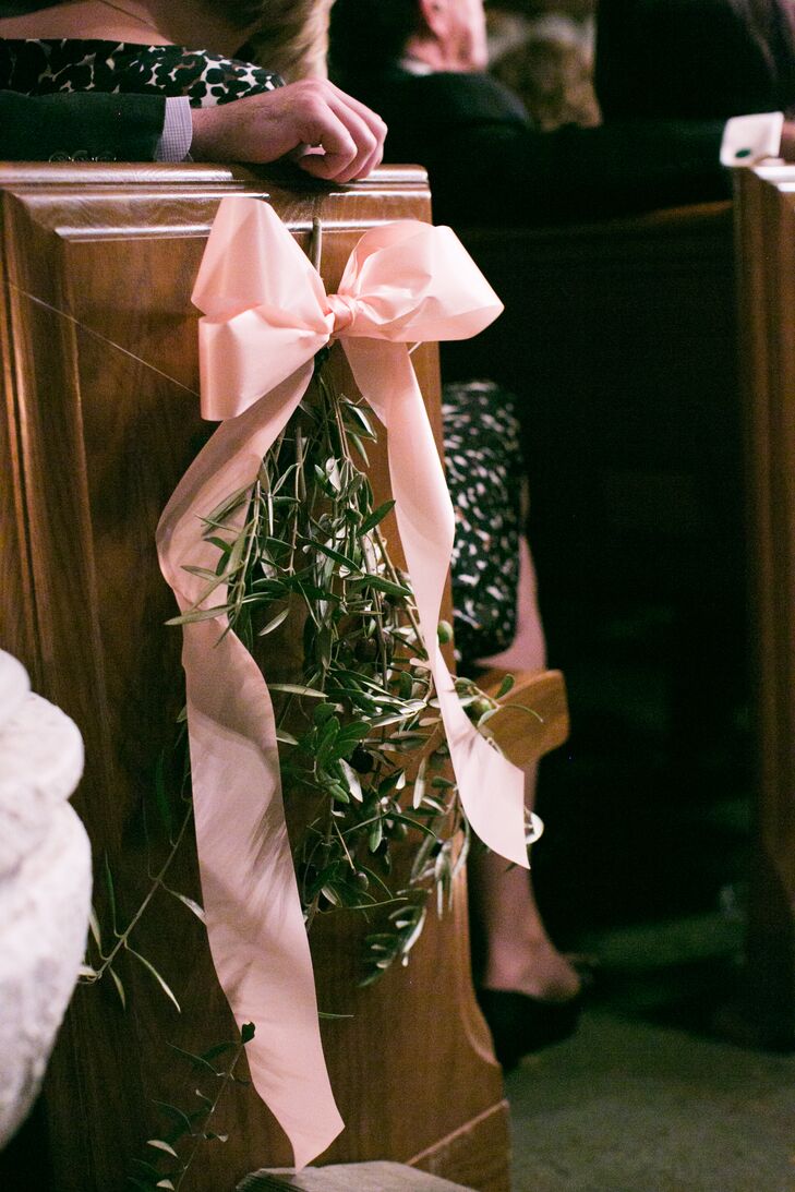 Olive boughs tied together with pale pink bows added a natural, decorative touch to alternating rows lining the ceremony aisle.