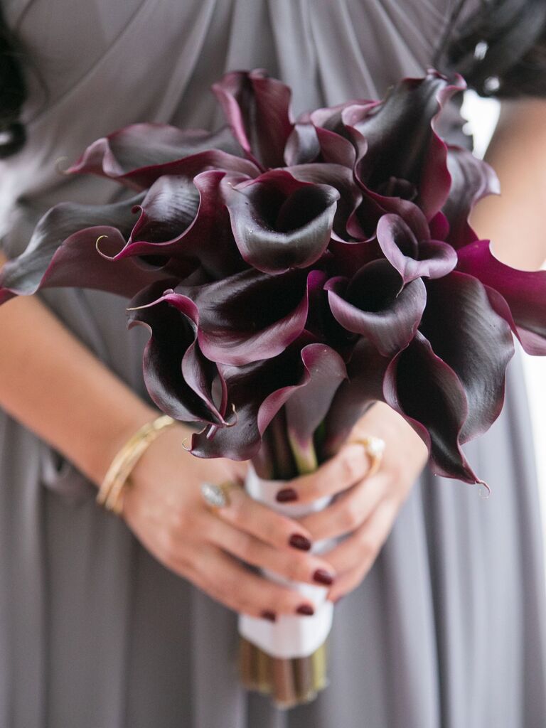 A bridesmaid holds this dramatic purple lily bouquet.