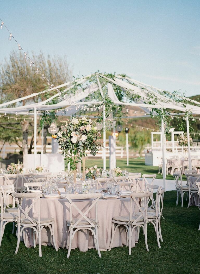 Outdoor wedding reception with neutral color palette and greenery