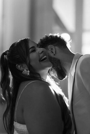 Black and White Photo of Bride in Half Up, Half Down Hair Smiling With Groom