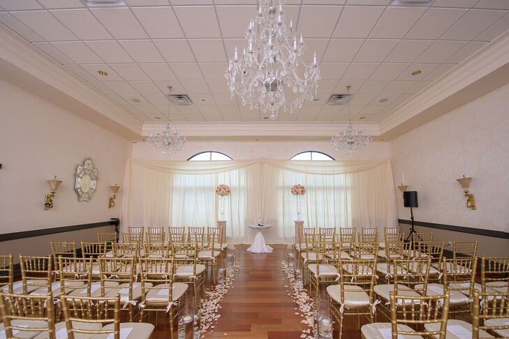 Chanel and Q accented their ceremony with gold chiavari chairs, draped neutral fabric, romantic flower petals and two lush floral arrangements alongside the altar.