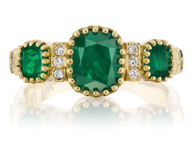 Triple emerald stone in gold halo with diamond accents on gold band