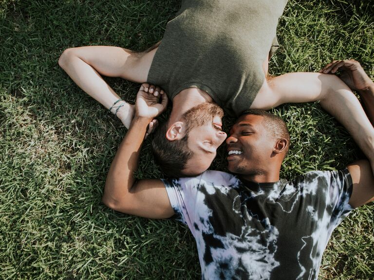 Twin flame couple laying on grass.