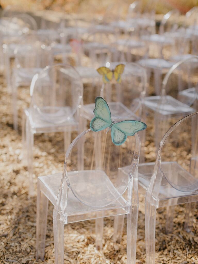 clear acrylic ghost chairs at outdoor wedding ceremony decorated with light green butterfly