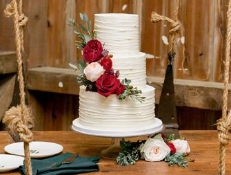 white buttercream wedding cake with red roses