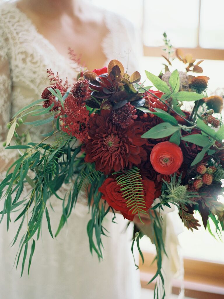 winter wedding bouquet with red dahlia, ranunculus, berries, roses and greenery