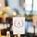 Ann and her family collected several green glass wine bottles months before the wedding, and they used the corks to hold up table numbers decorated with wreath designs.