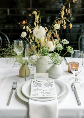Rehearsal Dinner Place Setting With White Chargers, Linens and Simple, Bespoke Menu With Low Arrangements in Neutral Vases