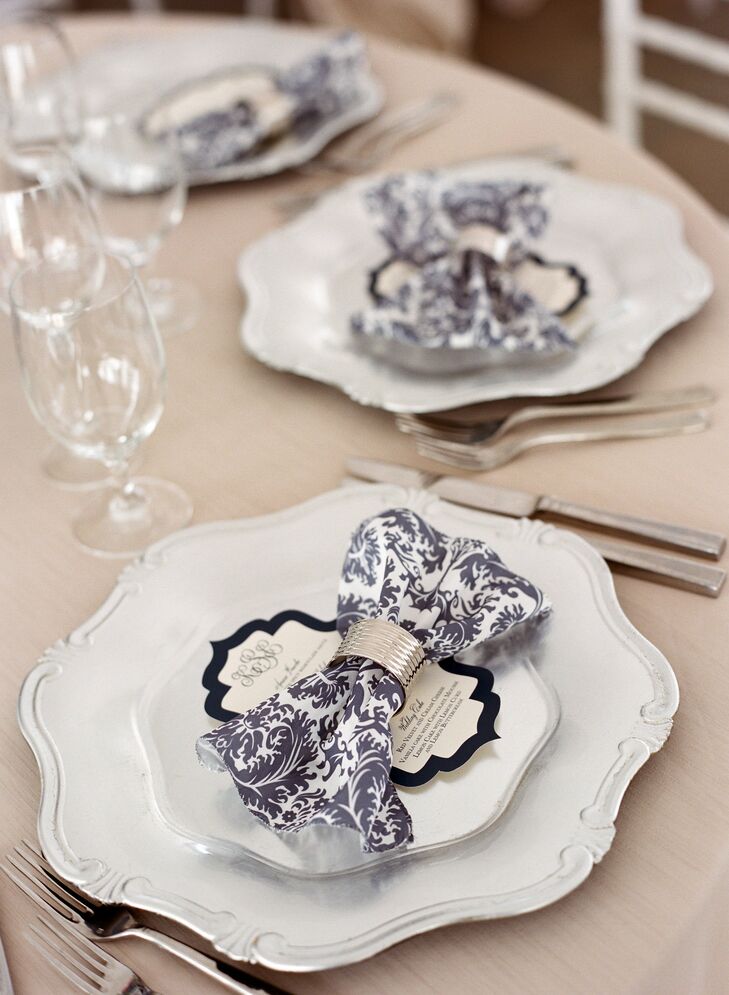 Baroque style plates with navy damask napkins in silver napkin rings came together to create stately place settings.