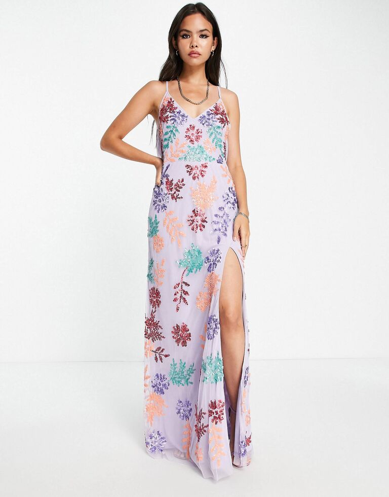 Model wears a lavender colored floor-length dress with colorful sequin embellishments. 