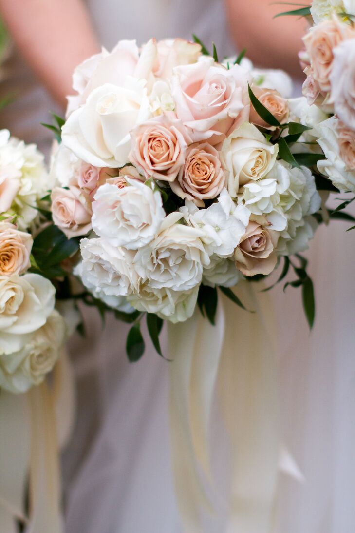 Emily's bridesmaids carried smaller versions of her own rose bouquet wrapped in an ivory satin ribbon.