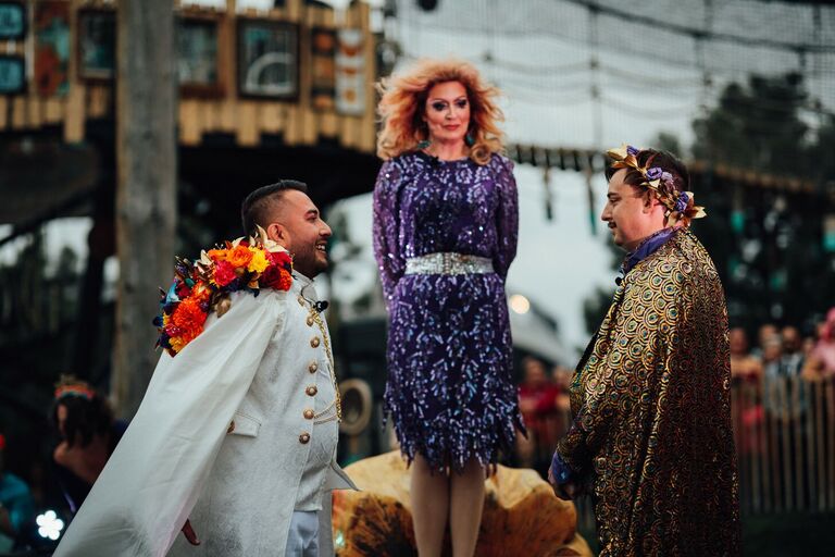 LGBTQ+ couple exchanging vows with drag queen as officiant