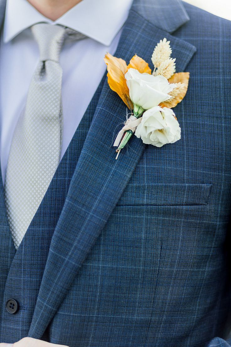 Boutonniere with white flower and dried leaves