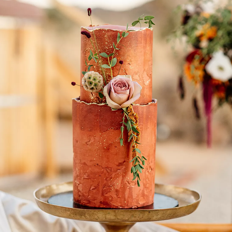 Copper wedding cake with flowers and greenery