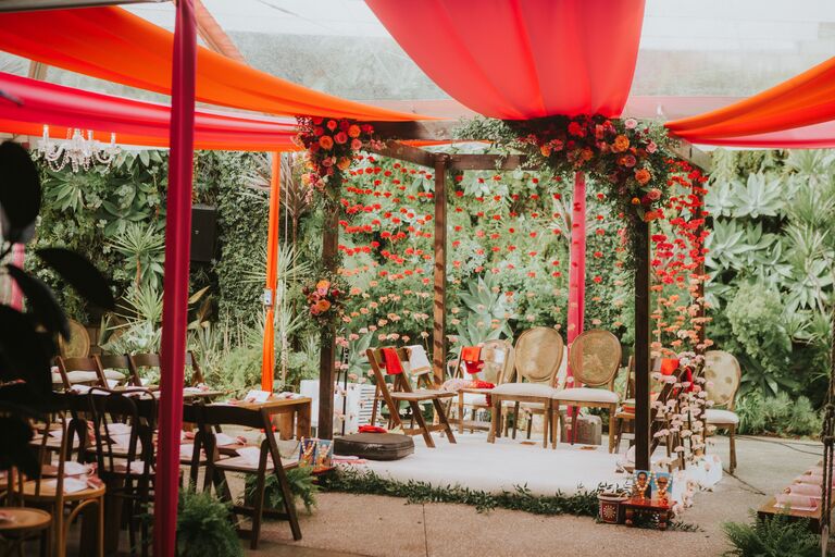 Mandap with vibrant orange fabric accents
