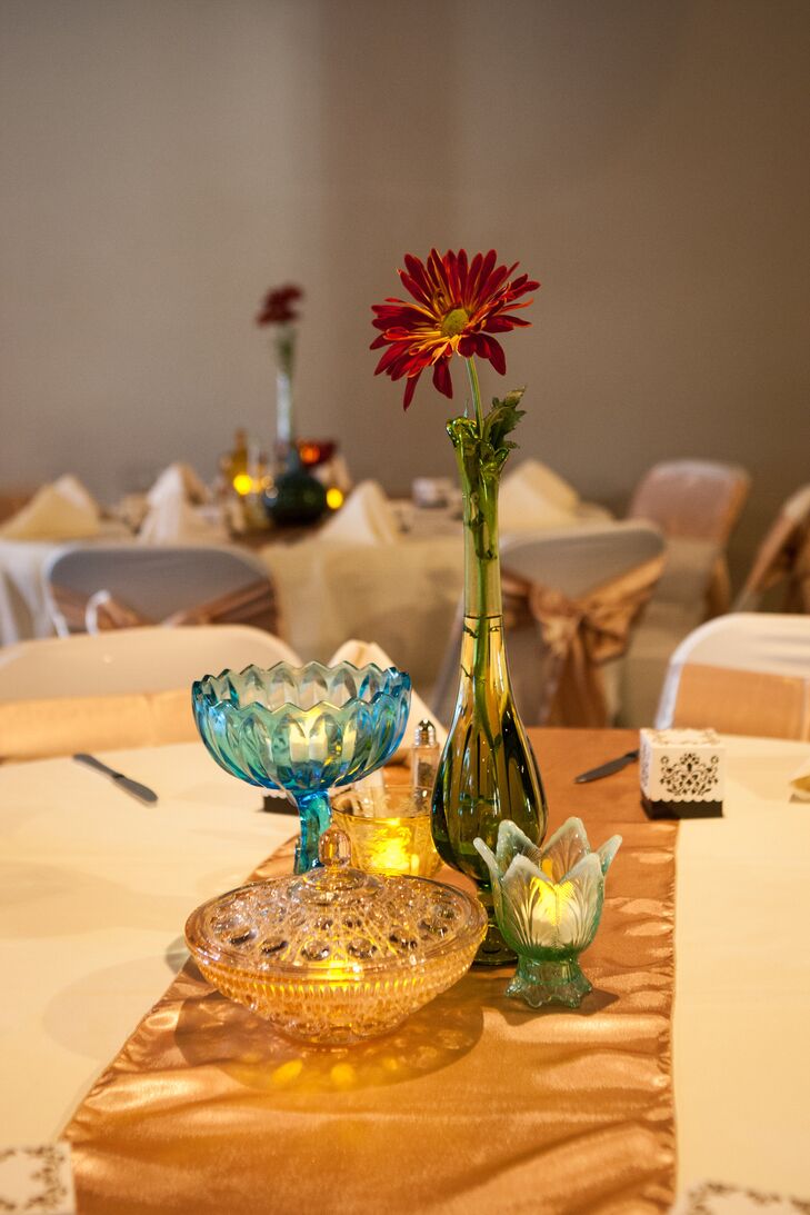 "We chose to forgo the majority of the flowers because they are so costly and get thrown away," Laura says. "We had two large fall arrangements strategically placed in our ceremony and reception, mums at the entrance, as well as various single blooms placed throughout the tables to add warmth to the vintage glass."