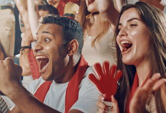 Couple cheering at sports game in stands