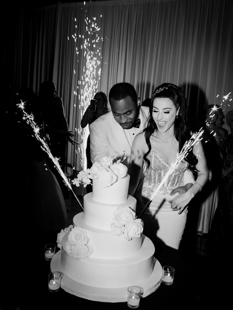 Four-tiered wedding cake with sparklers for a glam wedding