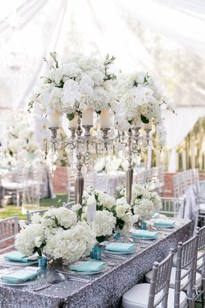 Tall Candle Centerpiece with Orchids on Silver Glitter Tablecloth