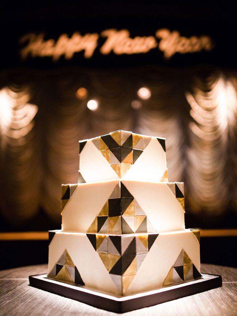 Square three-tier white wedding cake with black, gold and silver Art Deco pattern