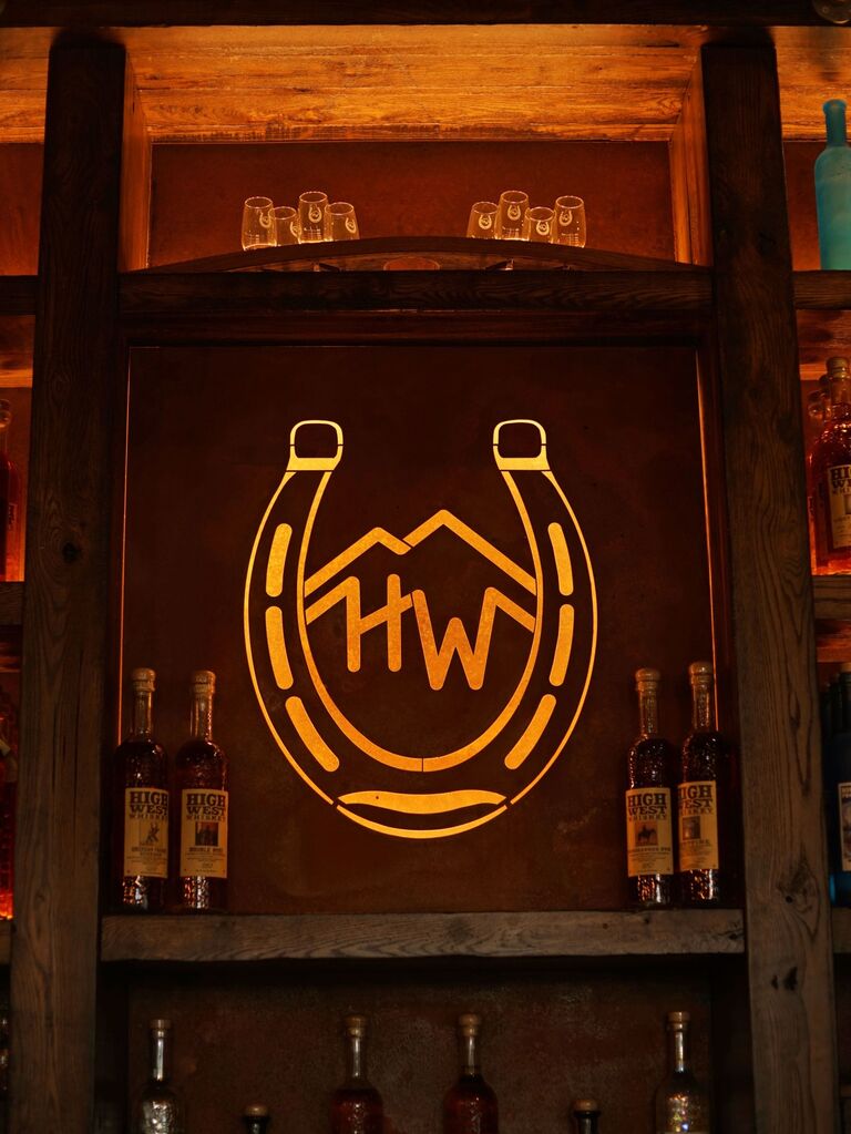 Gold horseshoe-shaped monogram in the center panel of a bar. 