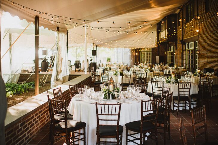 The reception was held on a tented brick porch at Greenville Country Club. Bistro lights were strung from the ceiling. Tables were covered in white tablecloths and featured lantern centerpieces.