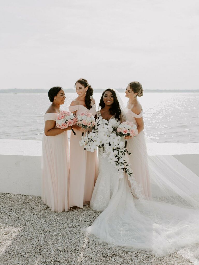 Bridesmaids and bride posing in front of scenic waterfront