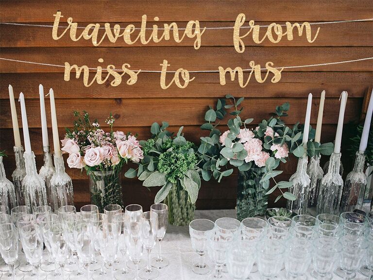 'traveling from miss to mrs' in sparkly gold script banner