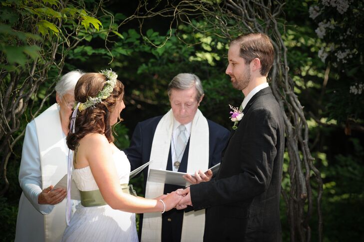 Christine and Mike stood at the altar shaped by the branch wedding arch and were married outside at The Holden Arboretum in Kirtland, Ohio, by their officiant. Christine wore a sage green sash with her ivory wedding dress, which matched Mike's tie. "I wanted something simple but elegant, and I wanted to bring in a little thematic color," Christine says. "I wore a sage green sash that matched my husband's tie and our wedding colors."