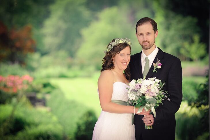 Christine held her lush ivory, green and purple bouquet that was filled with roses and lavender  accented with leaves, which was arranged by Avalon Gardens. The bouquet matched Mike's boutonniere, which was made of purple and ivory roses accented with greenery. The couple matched in wedding attire through Christine's sage sash and Mike's sage tie.