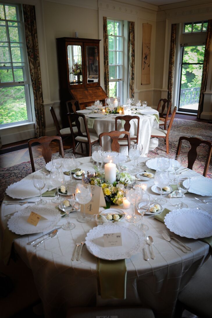 The reception dinner was held inside the Lantern Court Arcade at The Holden Arboretum in Kirtland, Ohio. Round dining tables were dressed in white linens and set with antique dinnerware covered in paper. Yellow and purple flower centerpieces decorated the middle of the tables, which were made up of roses accented with eucalyptus and other greenery.