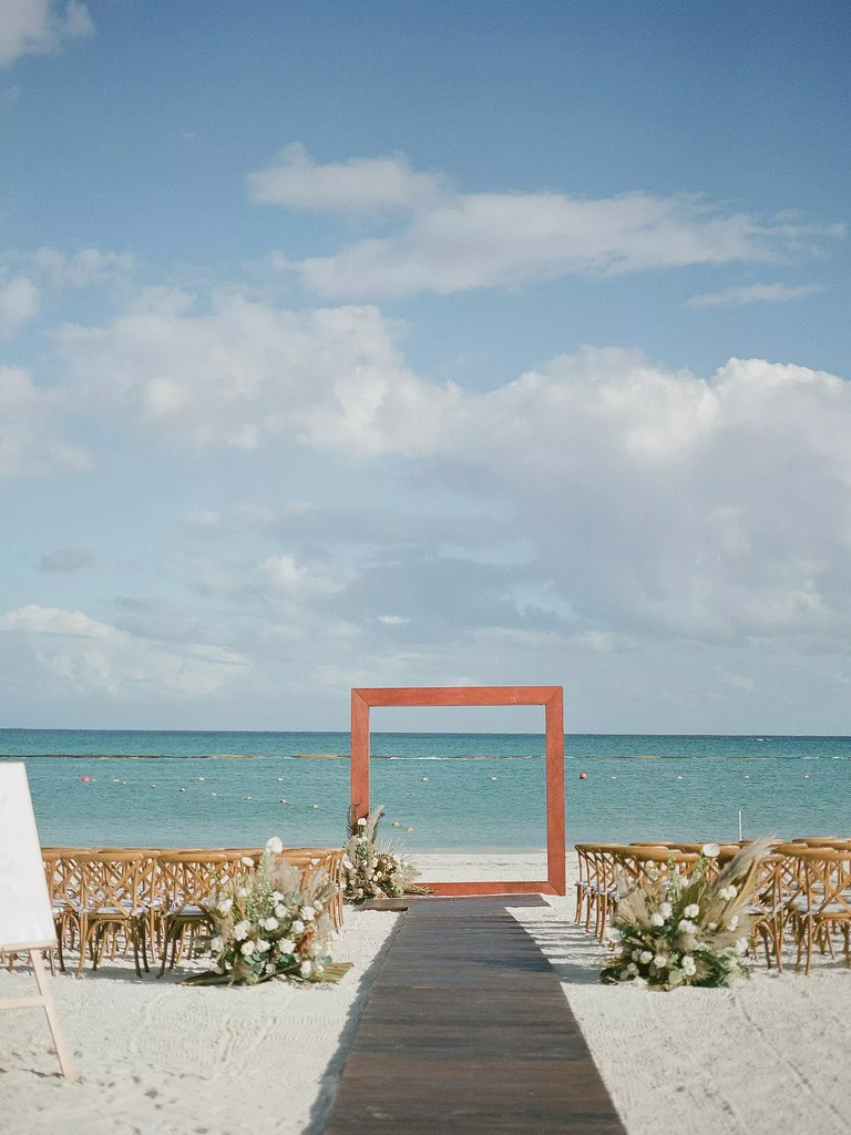 A modern geometric archway at a beachside wedding.