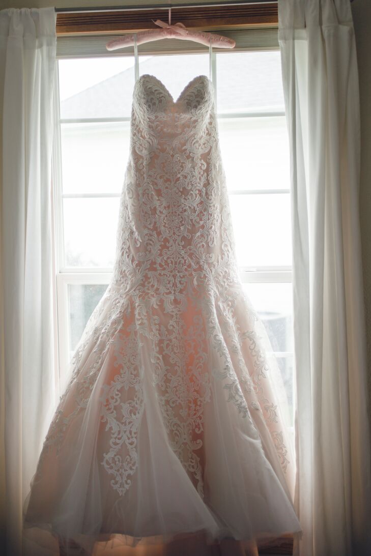 A champagne underlay gave a slight rose hue to the bride's strapless, trumpet-fit lace gown from Allure.