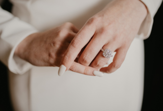 Woman's hands with cream wedding nail manicure and diamond ring
