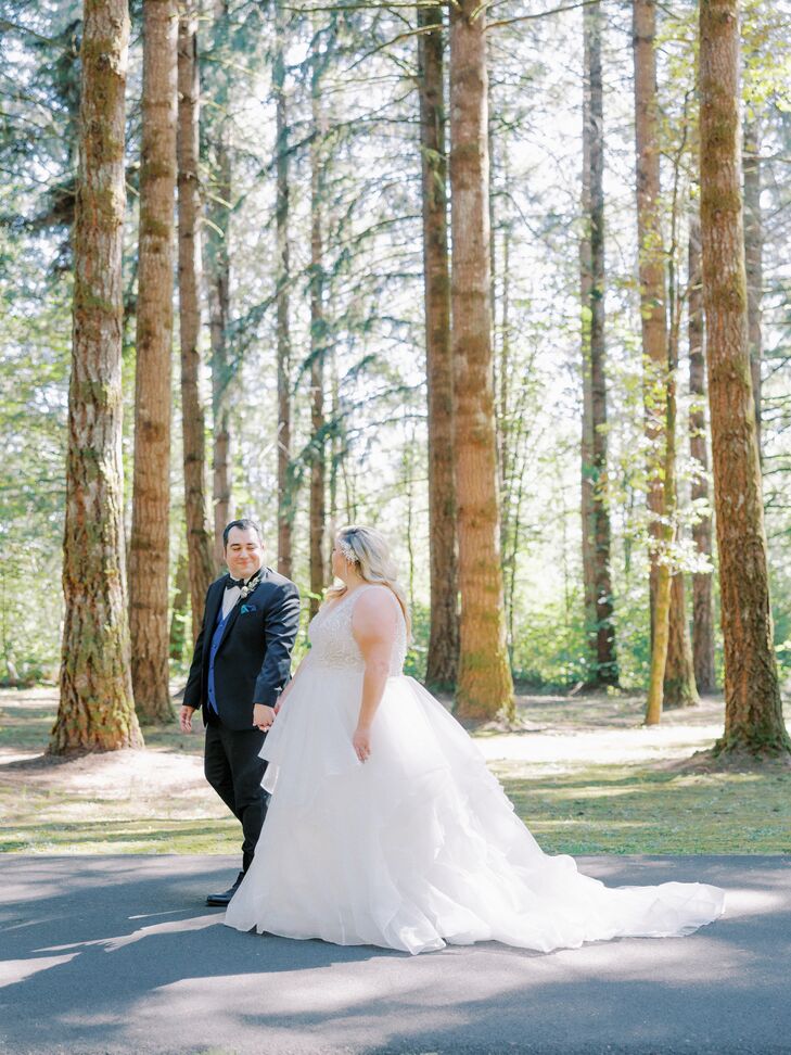 Bride With Wedding Dress Train and Groom in Tuxedo Walk in Forest