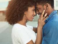Black couple smiling at each other.