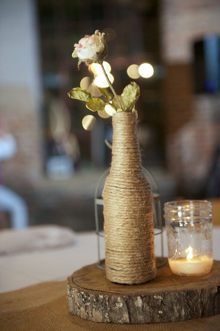 In addition to the lush ivory floral arrangements, the reception tables were also decorated with simple bunches of ivory spray roses placed in homemade twine-wrapped vases.