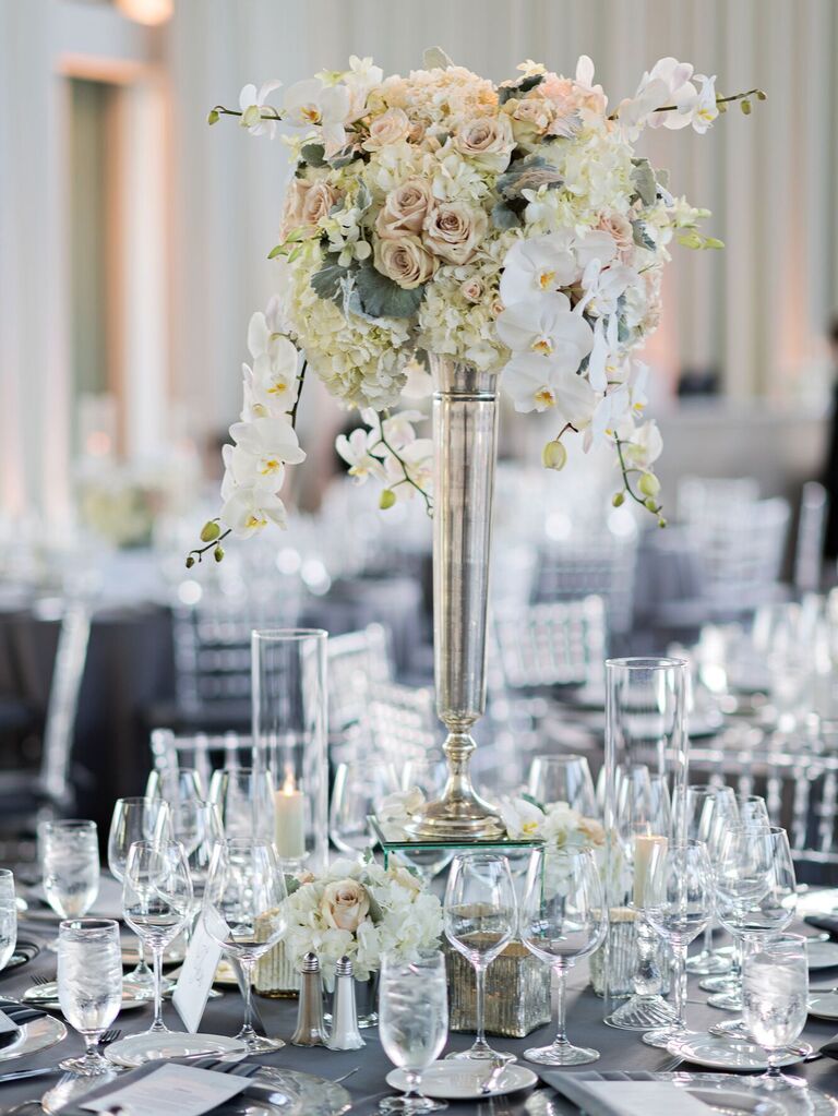 classic tall wedding centerpiece with white roses, hydrangeas and phalaenopsis orchids in silver vase