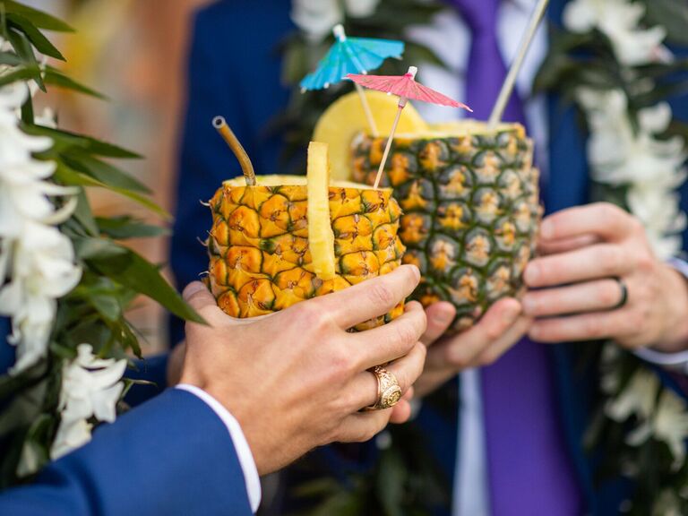 Husbands wearing wedding rings and holding drinks at wedding