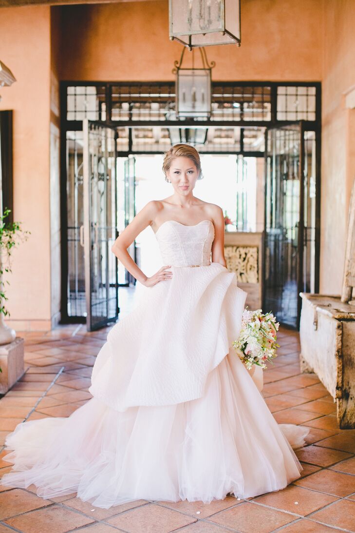Patricia was focused on finding an off-the-shoulder A-line gown with a flowy chiffon skirt at the start of her wedding dress search, but the gown she ultimately said “I do” in could not have been more different. While trying on dresses one afternoon, she spotted a blush ball gown with dramatic textural tulle and a strapless peplum bodice and at the urging of her friend took the plunge and tried it on. “Once I did, I quickly signed off on it. The blush tone is what really appealed to me and I was able to get two dresses out of it,” says Patricia. “For the late night dancing I was able to rip off the tulle skirt and use the peplum portion as a party dress.