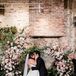 Bride Holding Bouquet of White and Ivory Flowers With Greenery