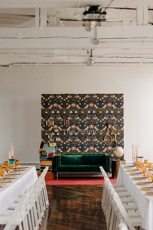 Custom Photo Backdrop Themed Around Wes Anderson Movies With Green Velvet Couch