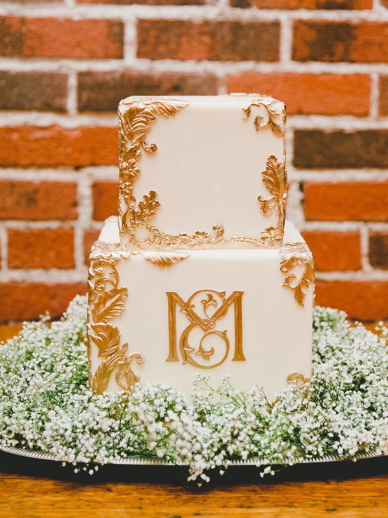 Glamorous gold and white wedding cake with a metallic monogram