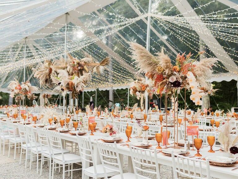tall boho wedding centerpiece with orange roses, white orchids and pampas grass