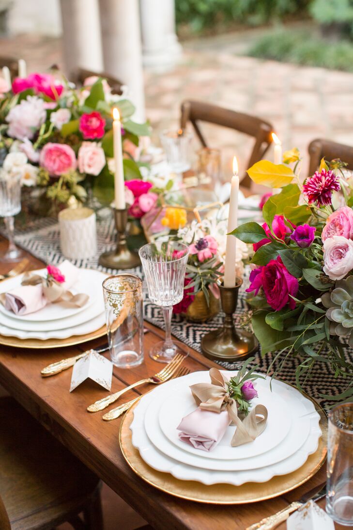 Tables were embellished with blue and white geometric table runners, pretty pink flower arrangements and gold decor.