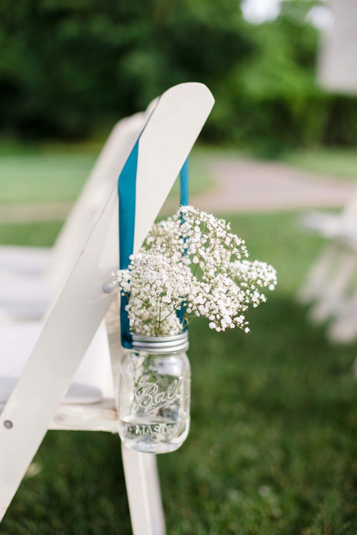 The white folding chairs that lined the aisle at the outdoor ceremony had mason jars hanging from blue ribbon. A collection of baby's breath filled out the glass mason jars—a classic flower for a classic wedding.