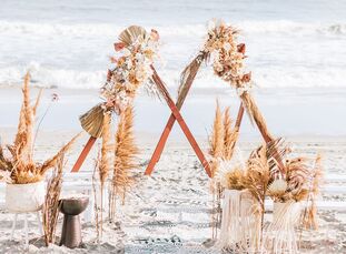 For their beach wedding in Ocean City, New Jersey, Lindsey and John expertly blended a boho-chic aesthetic with a sleek-and-moody color palette. The e