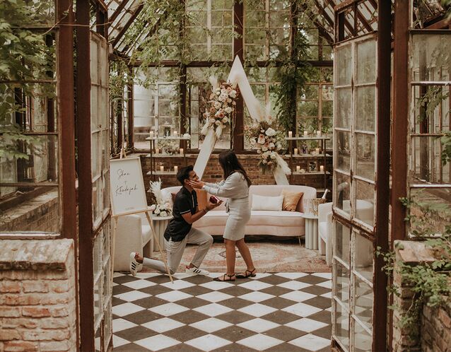 couple getting engaged in a beautiful indoor garden